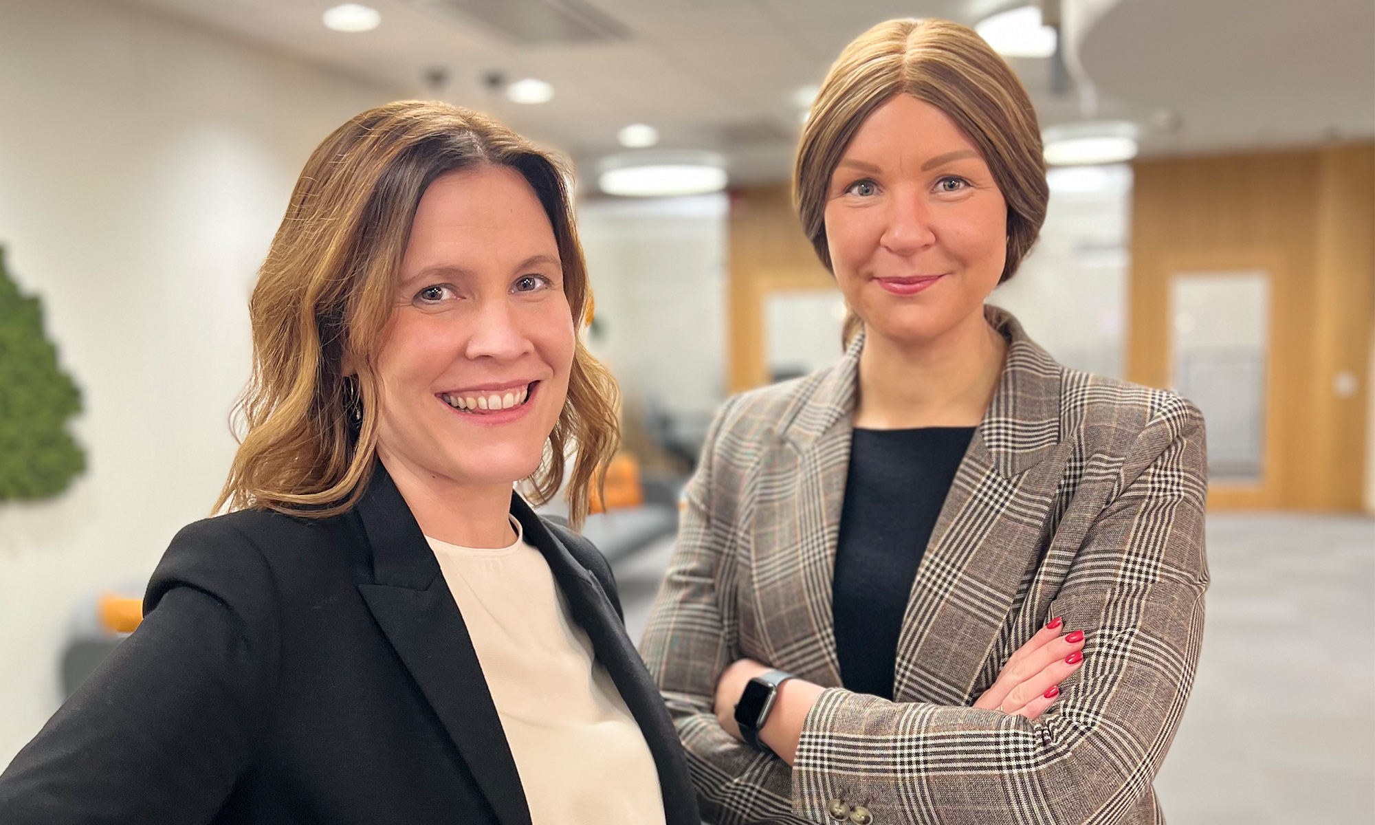Two confident women standing in office landscape