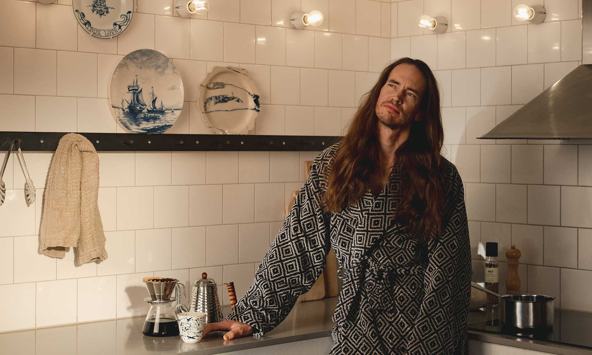 Man njuter av en kopp kaffe vid köksbänken.